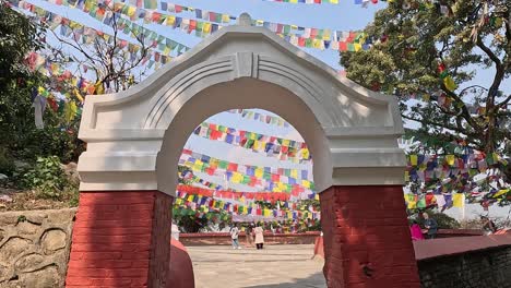 Disparo-De-Apertura-Moviéndose-A-Través-De-Un-Arco-De-Ladrillo-En-Un-área-Con-Muchas-Banderas-De-Oración-Tibetanas-En-El-Cielo.