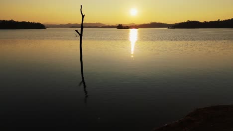 Una-Impresionante-Puesta-De-Sol-Adorna-Las-Tranquilas-Aguas-Del-Lago-Vajiralongkorn-En-Sangklaburi,-Tailandia