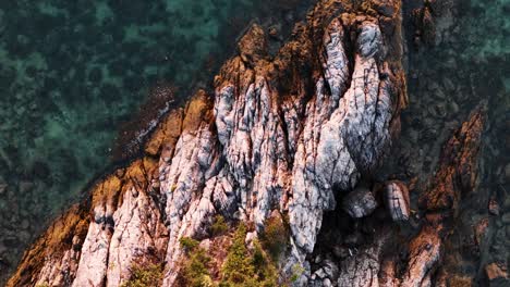 Top-down-view-of-rocky-cliff-meet-the-sea