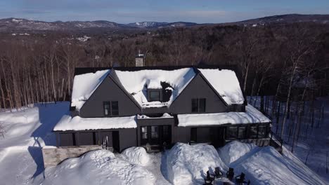 Luftaufnahme-Eines-Schneebedeckten-Luxus-Chalets-Im-Winter,-Das-Sich-Langsam-Dreht