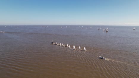 Optimist-boats-being-towed-on-river---aerial-view