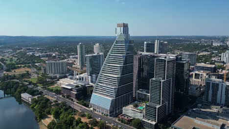 Descending-over-Colorado-river-with-revealing-view-of-iconic-buildings-in-Austin