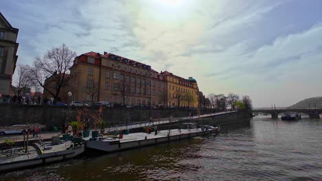 Boat-ride-on-Vltava-river-towards-Manes-Bridge-with-view-on-Divadlo-Na-Rejdišti-conservatory