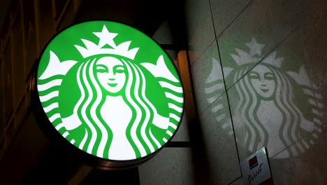 Logo-Der-Amerikanischen-Multinationalen-Starbucks-Kaffeekette-Mit-Eingeschaltetem-Schild-Während-Der-Nacht