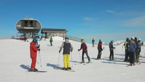 Skiers-and-snowboarders-wait-to-use-the-main-chairlift-in-winter