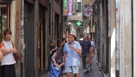 Clip-En-Cámara-Lenta-De-Gente-Caminando-Por-Una-Calle-Estrecha-En-Génova,-Italia