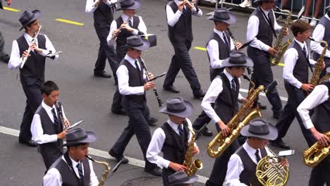 Student-musicians-from-Brisbane-Grammar-School-Band-performing-musical-instruments,-marching-down-the-street-in-Anzac-Day-parade,-close-up-shot
