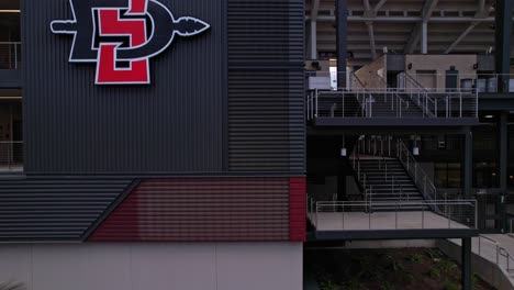 Aerial-vertical-climb-up-from-the-ground-to-the-sky-on-the-west-side-of-Snapdragon-Stadium-by-drone-close-up-to-the-stadium