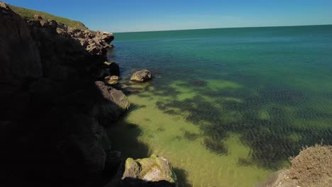 Momentos-De-Paz-Bajo-Imponentes-Acantilados,-Donde-Las-Suaves-Olas-Arrullan-Las-Serenas-Costas,-Ofreciendo-Un-Escape-Tranquilo.