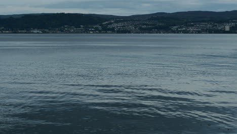 Slow-motion-water-in-front-of-distant-seaside-town