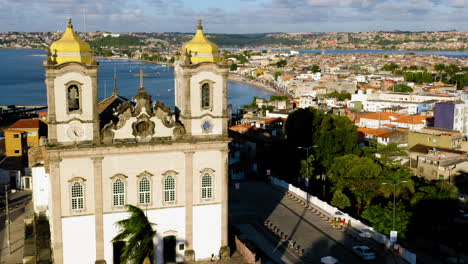 Luftaufnahme-Der-Kirche-Nosso-Senhor-Do-Bonfim,-Der-Umgebenden-Stadt-Und-Dem-Meer-Im-Hintergrund,-Salvador,-Bahia,-Brasilien