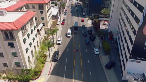 Aerial-Footage-of-Ambulance-Driving-Down-Sunset-Boulevard-in-the-Day,-Large-Billboards-and-Cars-in-Frame