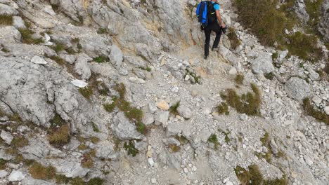 Aerial-View-Of-Backpacker-Hiking-Over-Mountain-Side-In-Lecco-Alps