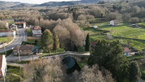 Drone-descends-to-Medieval-bridge-of-arnuide-in-vilar-de-barrio,-ourense,-galicia,-spain