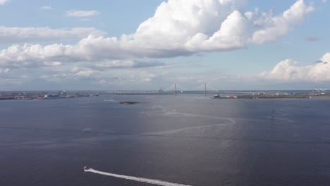 Super-wide-aerial-dolly-shot-of-Charleston-Harbor-with-Patriot's-Point,-Castle-Pinckney,-and-Ravenel-Bridge-all-visible,-from-the-perspective-of-Fort-Johnson-off-James-Island,-South-Carolina