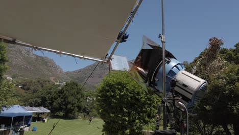 Outside-Arri-lighting-on-daylight-set-with-a-field-and-mountains-on-background,-foldaway-overhead-frame
