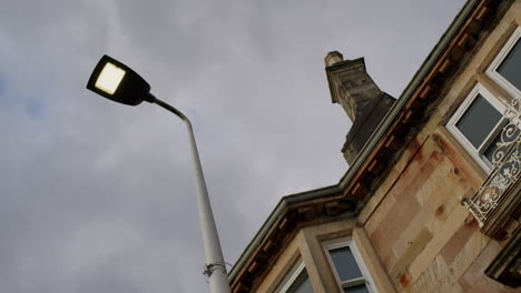 Streetlamp-and-stone-house-low-angle-with-cloudy-sky