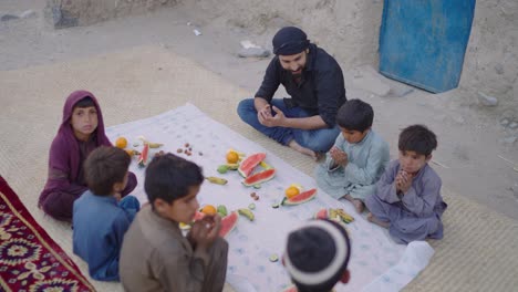 Pakistani-man-with-few-children-having-their-Ramadan-iftar-at-evening-in-Balochistan-,-Pakistan