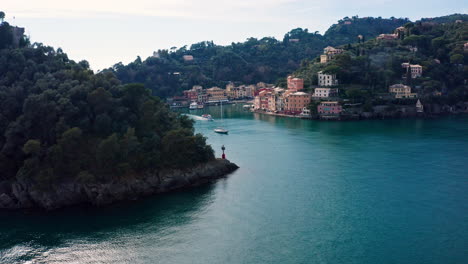 Aerial-view-of-tourist-boat-departing-scenic-Portofino-on-Ligurian-coast,-Italy