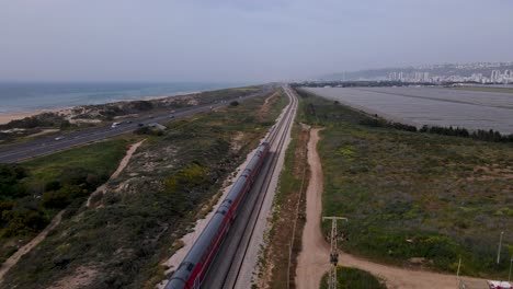 Commuter-Train-Running-On-Rail-Track-On-Mediterranean-Coast-In-Megadim-Moshav,-Israel