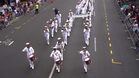 Royal-Australian-Navy-Band-followed-by-TS-Gayundah-Australian-Navy-Cadets-marching-down-the-street-at-Anzac-Day-parade,-commemorating-those-who-served-and-sacrificed-during-wartime-conflicts