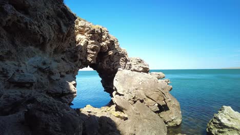 Capta-La-Impresionante-Vista-Del-Mar-Enmarcado-Por-Un-Arco-De-Roca-Natural,-Ofreciendo-Una-Pintoresca-Vista-Costera.