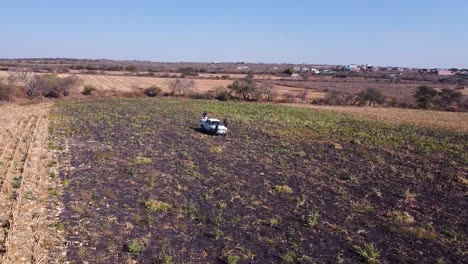 órbita-De-Vista-Aérea-Que-Revela-La-Ciudad-Y-Los-Agricultores-En-La-Cosecha-De-Cultivos-De-Garbanzos,-Guanajuato-México