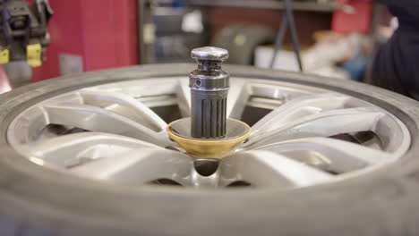 Rotating-wheel-on-bead-breaker-machine-in-repair-workshop,-close-up