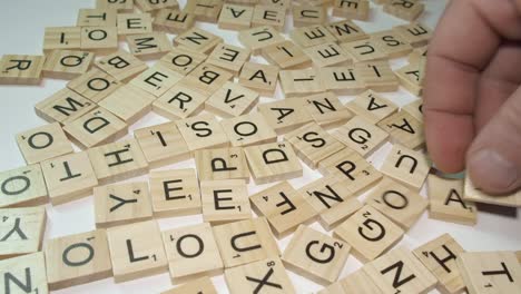 Zeitrafferaufnahme-Einer-Tischplatte:-Scrabble-Buchstabensteine-Umgedreht-Auf-Einem-Weißen-Tisch