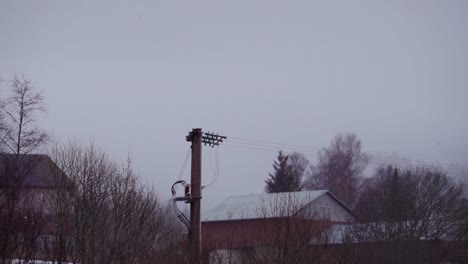 Übertragungsleitung-Und-Hausdächer-Mit-Nebelwolken-Im-Hintergrund