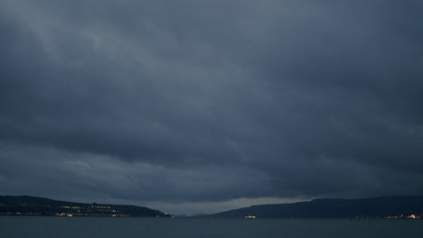 Timelapse-De-Pesadas-Nubes-Azules-Pasando-Y-Barcos-En-La-Distancia-Pasando-Rápidamente-Con-Sus-Luces-Encendidas