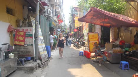 Por-Los-Estrechos-Callejones-De-La-Ciudad-Pasan-Residentes,-Visitantes-Y-Motocicletas.