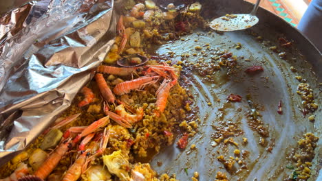 Schöpfen-Eines-Traditionellen-Spanischen-Paella-Gerichts-Mit-Meeresfrüchten,-Garnelen,-Jakobsmuscheln-Und-Kaisergranat-(Nephrops-Norvegicus),-Gekochtem-Reis-Mit-Meeresfrüchten,-Marbella,-Spanien,-4K-Aufnahme