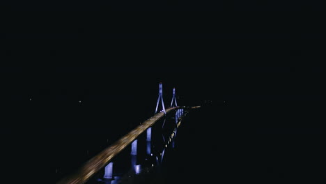 Empty-cable-stayed-bridge-at-night,-aerial-drone-view,-illuminated-blue-light