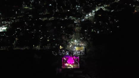 Vista-Aérea-De-Drones-Hacia-Arriba-Donde-Se-Celebra-Mahashivratri-Y-El-Espectáculo-De-Iluminación-Es-Visible