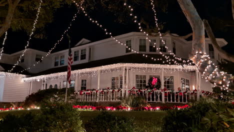 Walking-at-a-white-house-in-a-corner-of-los-angeles-during-christmas-night-with-garden-trees-and-decoration-traditional-american-house