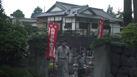 Camera-follows-two-japanese-men-in-work-clothes-leave-a-cemetery-in-Fujikawaguchiko