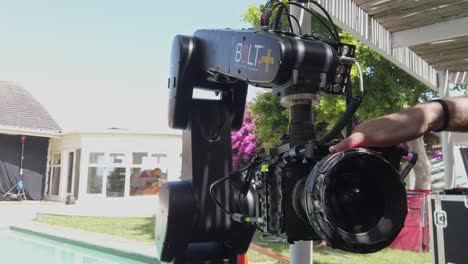 Operator-adjusting-aperture-on-a-robotic-high-speed-Bolt-plus-camera-on-set