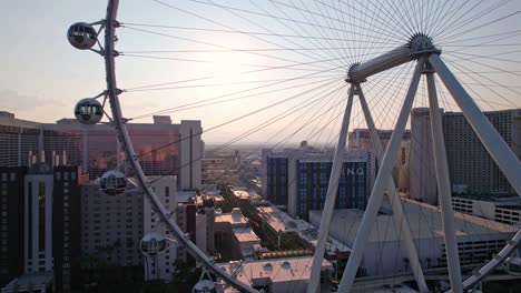 Luftaufnahmen-Der-Sonne-Durch-Das-High-Roller-Riesenrad-Von-Der-Kante-Des-Rades-Aus,-Verfolgt-Durch-Die-Mitte-Des-Rades-An-Einem-Wolkenlosen-Abend-Mit-Einem-Goldenen-Schein