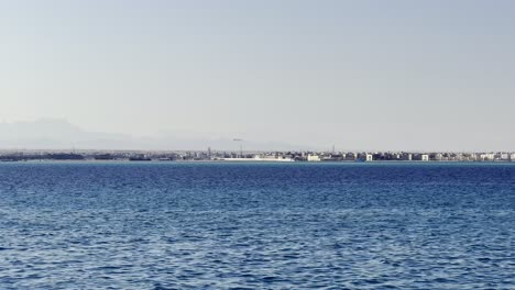Distant-View-Of-An-Airplane-Landing-At-Hurghada-Airport-View-From-The-Red-Sea-In-Egypt