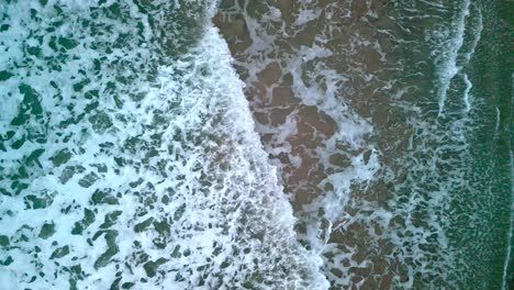 Static-aerial-shot-of-the-sea-as-the-waves-crash-together