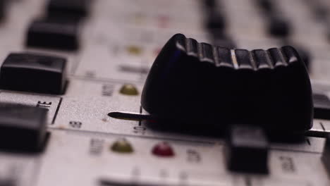 Moving-Fader-Up-and-Unmuting-Channel,-Audio-Mixing-Console-Detail-Macro-Close-Up