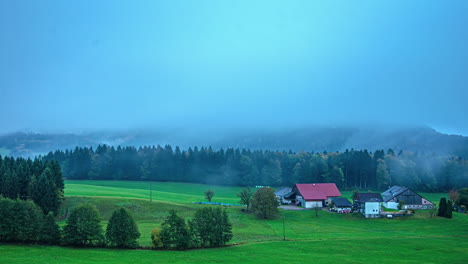 Zentralalpen,-Österreich,-Europa---Ein-Flugzeug-Flog-An-Der-Kleinen-Bergsiedlung-Vorbei,-Eingehüllt-In-Tiefliegenden-Nebel---Zeitraffer