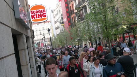 Pedestrians-walk-past-the-American-chain-of-hamburger-fast-food-restaurants-Burger-King-at-a-crowded-street-in-Spain