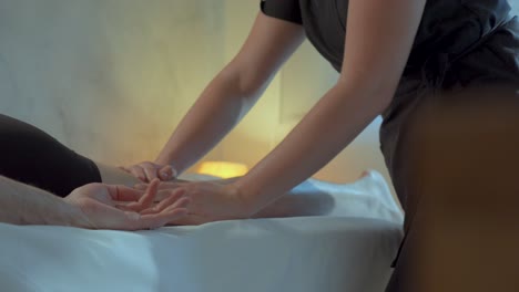 Therapist-expertly-massages-oil-on-legs-of-a-person-during-thalasso-treatment