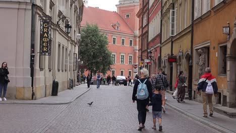 Tourists-walk-along-a-historic-and-well-maintained-street-in-the-Warsaw-square