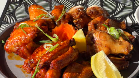 Hot-and-spicy-chicken-wings-in-sticky-bbq-sauce-with-spring-onion-and-a-lemon-slice,-tasty-Asian-cuisine,-4K-shot