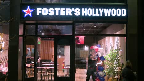 Un-Trabajador-De-Una-Tienda-Limpia-El-Escaparate-De-La-Cadena-De-Restaurantes-De-Comida-Americana-Foster&#39;s-Hollywood