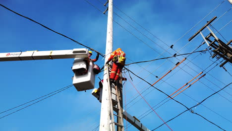 Toma-Amplia-En-ángulo-Bajo-De-Trabajadores-Hidroeléctricos-De-Toronto-En-Lo-Alto-De-Un-Poste