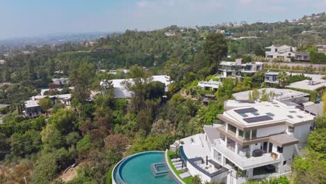 Flying-Over-Massive-Luxury-Homes-in-Beverly-Hills,-California-on-Sunny-Day,-Drone-Footage-of-Upscale-Community